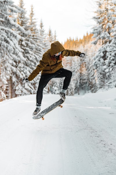 人在溜冰板上耍小把戏在冬季在半空中
